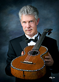 Dr. Douglas James holding classical guitar