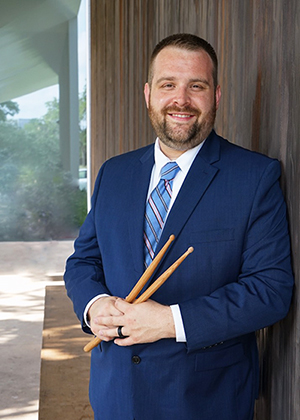 Dr. Brady Spitz poses with wooden drumsticks