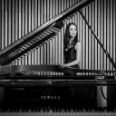 Elizabeth Schumann standing behind a grand piano