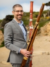 Dr. David A. Wells outdoors, holding modern and Baroque bassoons