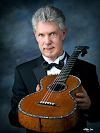 Dr. Douglas James holding classical guitar